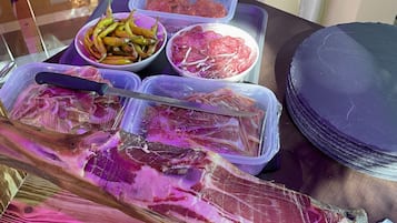 A table with various food items including sliced meats and vegetables.