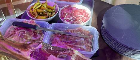 A table with various food items including sliced meats and vegetables.