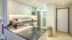 A modern kitchen with a large island, stainless steel appliances, and recessed lighting. - Gorgeous apartment in Orihuela (Orihuela)