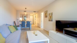 A modern living room with a sofa, coffee table, TV, and artwork on the wall. - Gorgeous apartment in Orihuela (Orihuela)