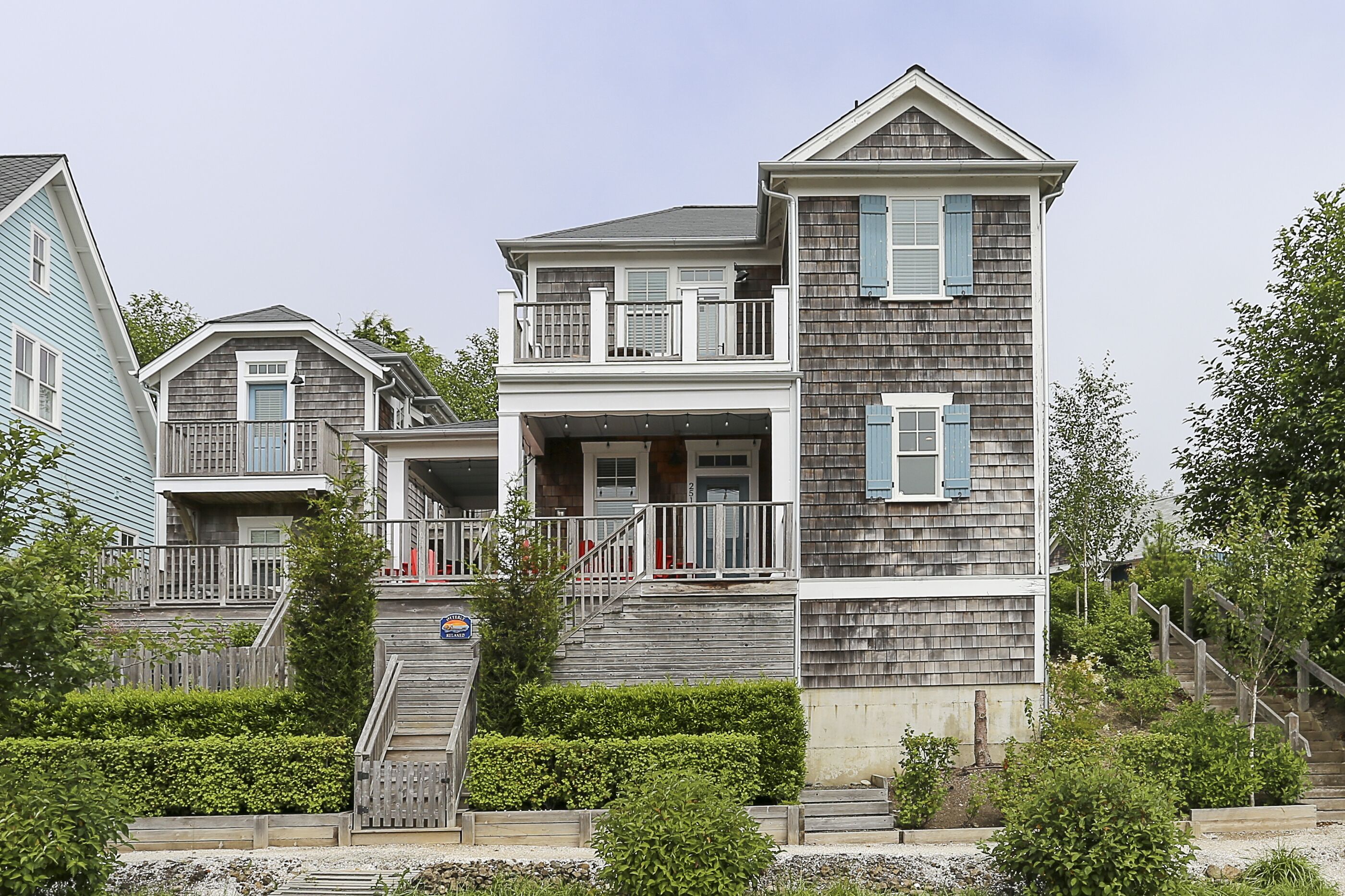 A two-story house with a balcony, a front porch, and a staircase leading to the entrance.