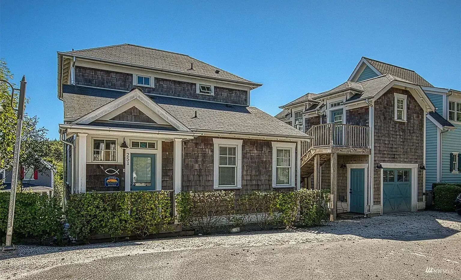 A two-story house with a front porch, a garage, and a driveway.