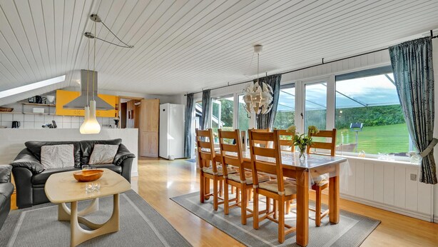 A modern living room with a dining area, large windows, and a view of a green landscape. - Lovely home in Roslev with WiFi (Roslev)