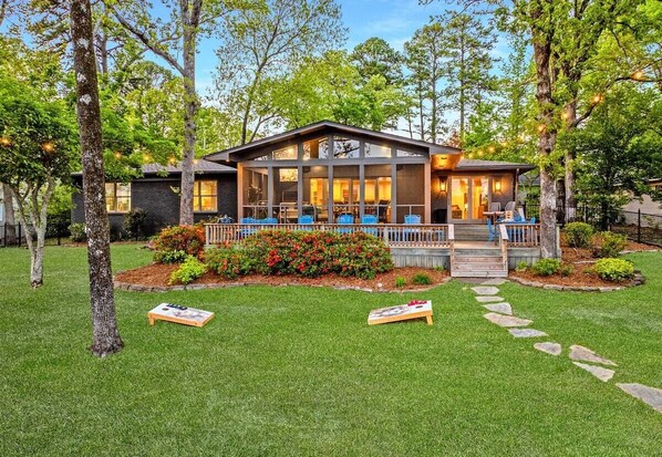 A modern house with a covered porch, a well-maintained lawn, and a stone pathway.