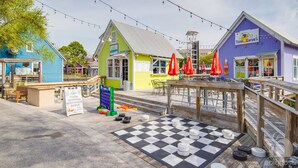A colorful outdoor dining area with a checkered floor, outdoor seating, and a sign advertising tacos, burritos, quesadillas, and beer. - KonaKai-Sandestin® 2BR/2.5BA Views-Walk to Beach! (Miramar Beach)