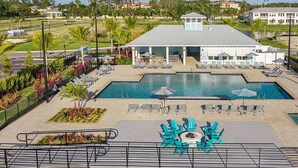 A pool area with lounge chairs and umbrellas, surrounded by landscaped gardens and a building with a grey roof. - Paradise in naples, few mins from downtown, beaches, mercato ...... (Naples)