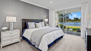 A bedroom with a large bed, a nightstand, a dresser, and a view of a lake through a glass door. - Paradise in naples, few mins from downtown, beaches, mercato ...... (Naples)