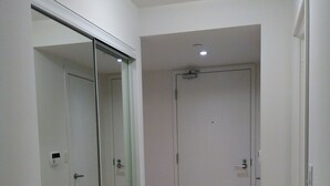 Un passadís amb una porta de vidre, una porta blanca i una catifa blanca al terra.