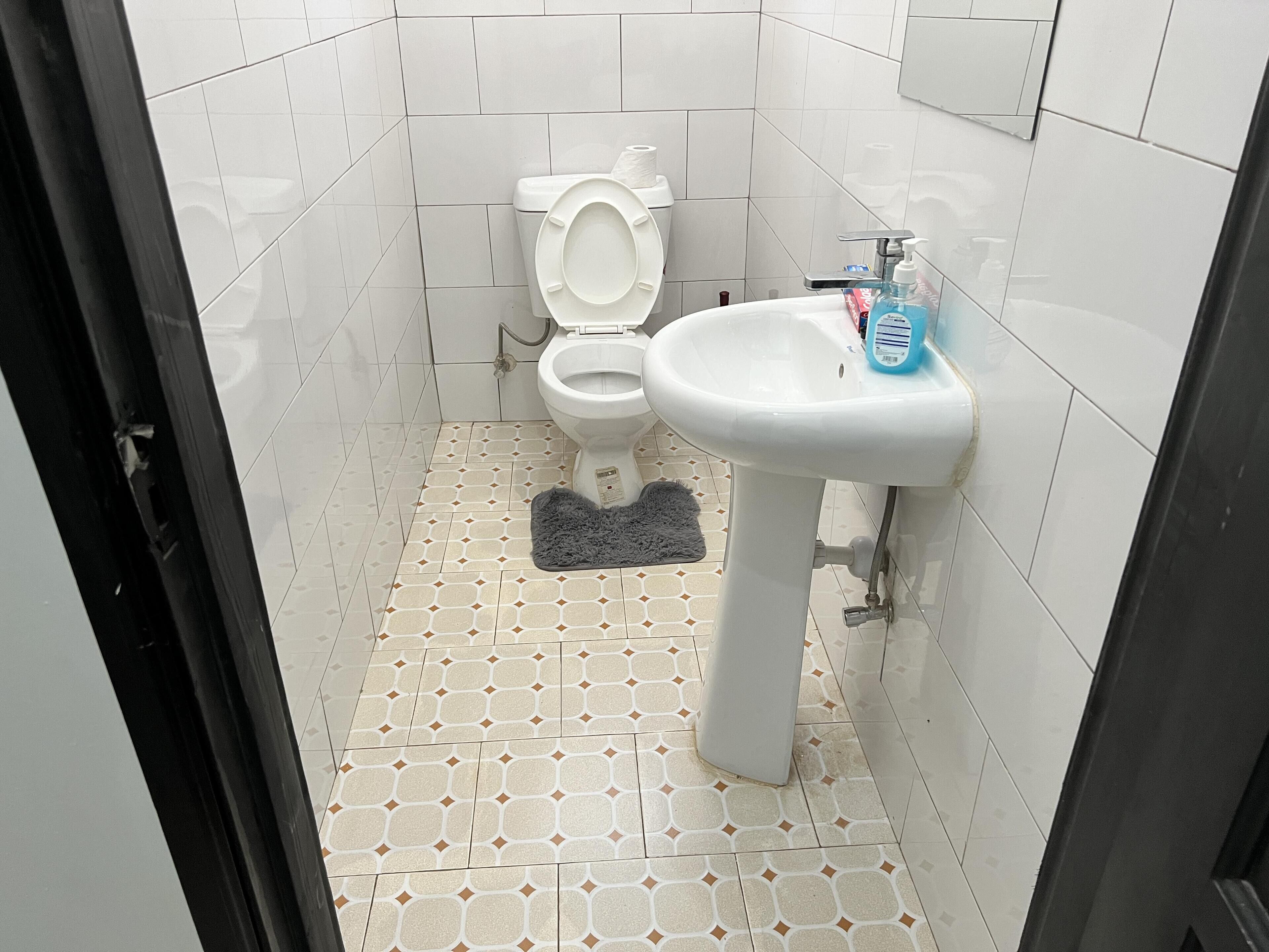 Une petite salle de bain avec des toilettes, un lavabo et des carreaux de sol à motifs.