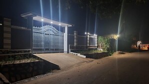 A gated entrance with a modern design, a paved driveway, and a well-lit area. - House - Sleeps 6 - Parking - Garden (Kampala)