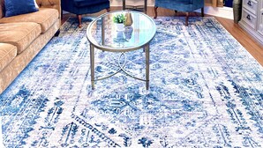 A living room with a blue sofa, two blue armchairs, a glass coffee table, and a chandelier. - Modern Victorian - 1910 Guesthaus (Hermann)