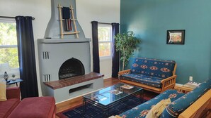 A living room with a fireplace, a sofa, a coffee table, and a ceiling fan. -  Three bedroom home near the University of New Mexico and heart of Albuquerque (Albuquerque)
