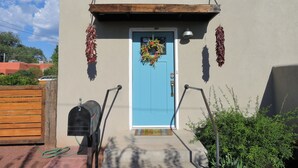 A blue door with a wreath, a mailbox, and a small porch with a wooden bench. -  Three bedroom home near the University of New Mexico and heart of Albuquerque (Albuquerque)