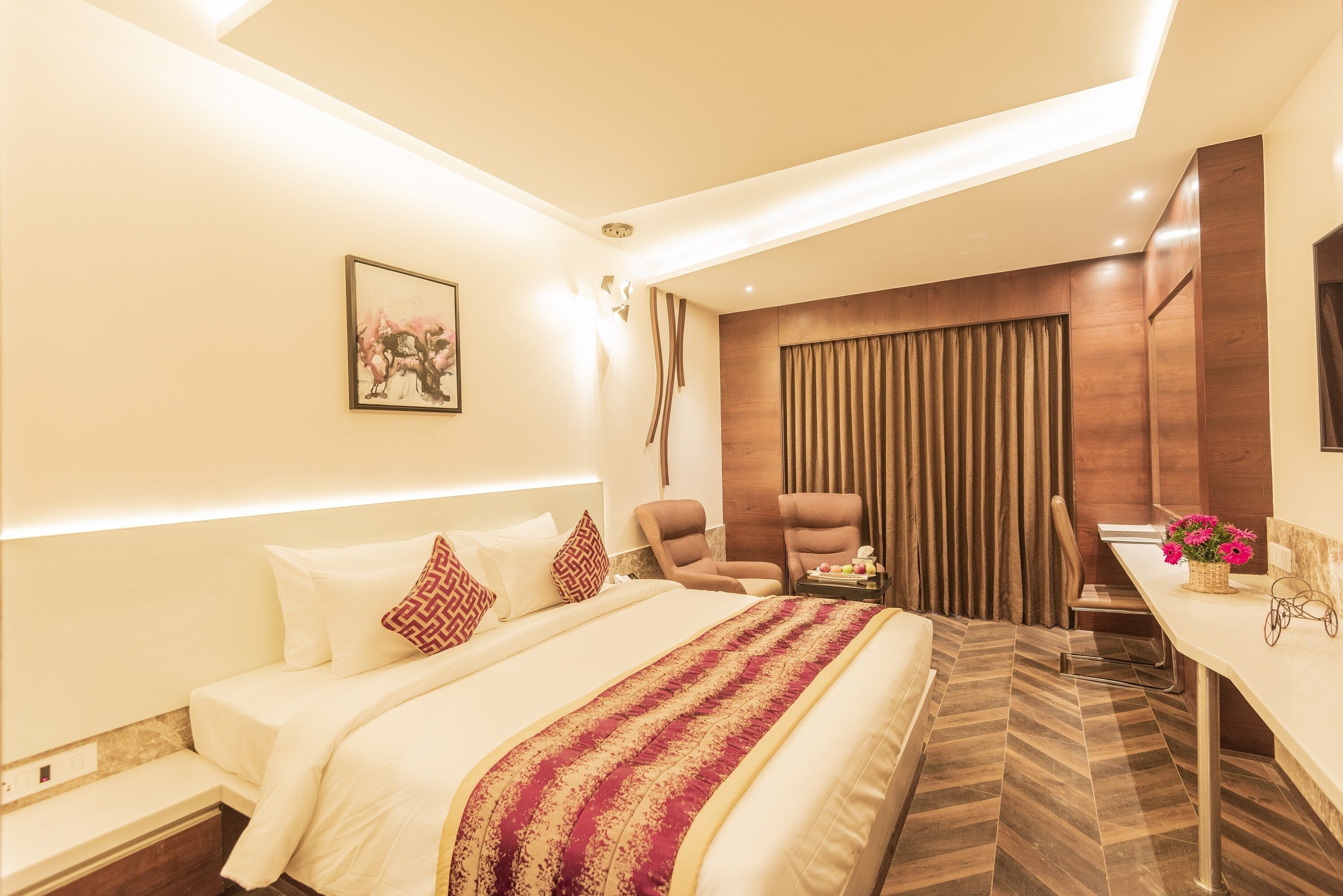 A modern hotel room with a large bed, a desk, and a chair.
