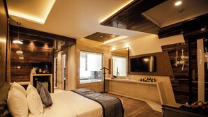 Una habitación de hotel moderna con una cama grande, un escritorio, un televisor y vistas a la ciudad.