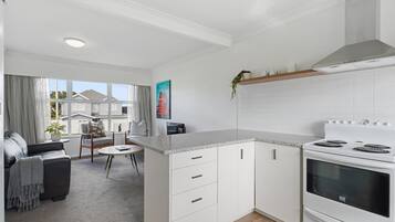 A modern kitchen with white cabinetry, a granite countertop, and a built-in oven.