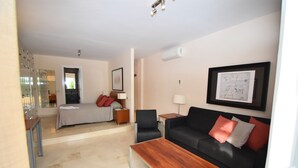 Una habitación de hotel moderna con cama, sofá, mesa de centro y escritorio.