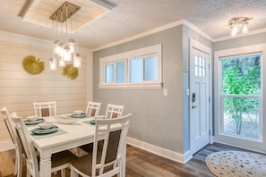 Enjoy meals in this dining area with a table for four, surrounded by matching chairs and a decorative fan.