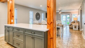 Una cocina amplia con una isla grande, vigas de madera y un comedor con vistas.