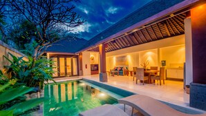 A modern house with a swimming pool, outdoor seating, and a well-lit interior. - Nomad Hub Canggu-Bali (Kerobokan)