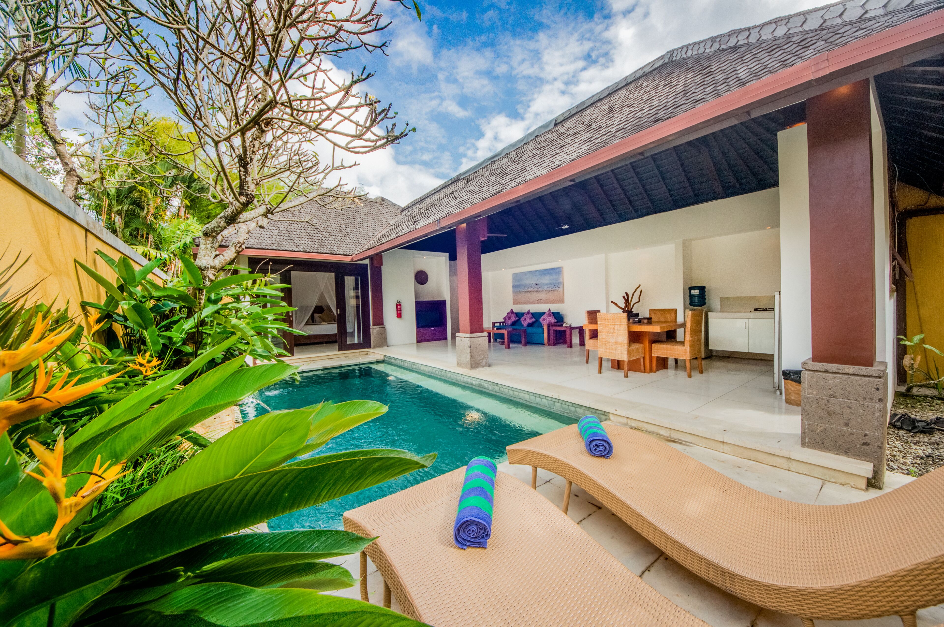 A poolside area with lounge chairs and a covered patio.