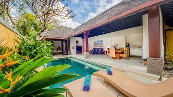 A poolside area with lounge chairs and a covered patio.