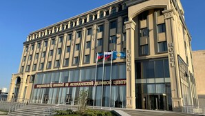 A large building with a classical architectural style, featuring a prominent entrance with steps and a large glass facade. - Volga Hotel (Baku)