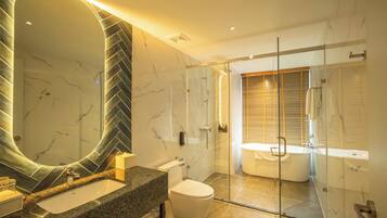 Un baño moderno con un espejo grande, una bañera y una zona de ducha.