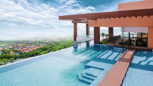 A rooftop infinity pool with a clear view of a cityscape and greenery. - La Vela Hue Hotel (Hue)