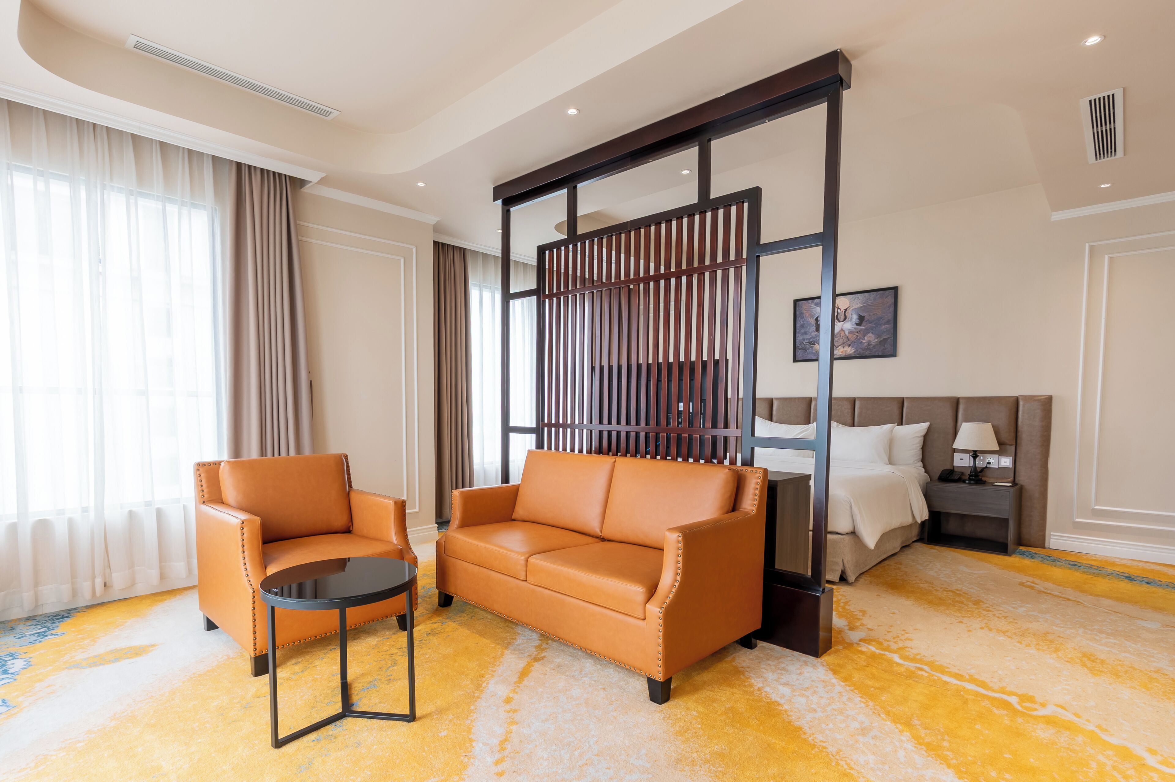 Habitación de hotel con sofá, sillón y una mesita.
