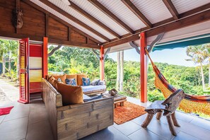 A wooden ceiling with a hammock and a sofa with cushions.