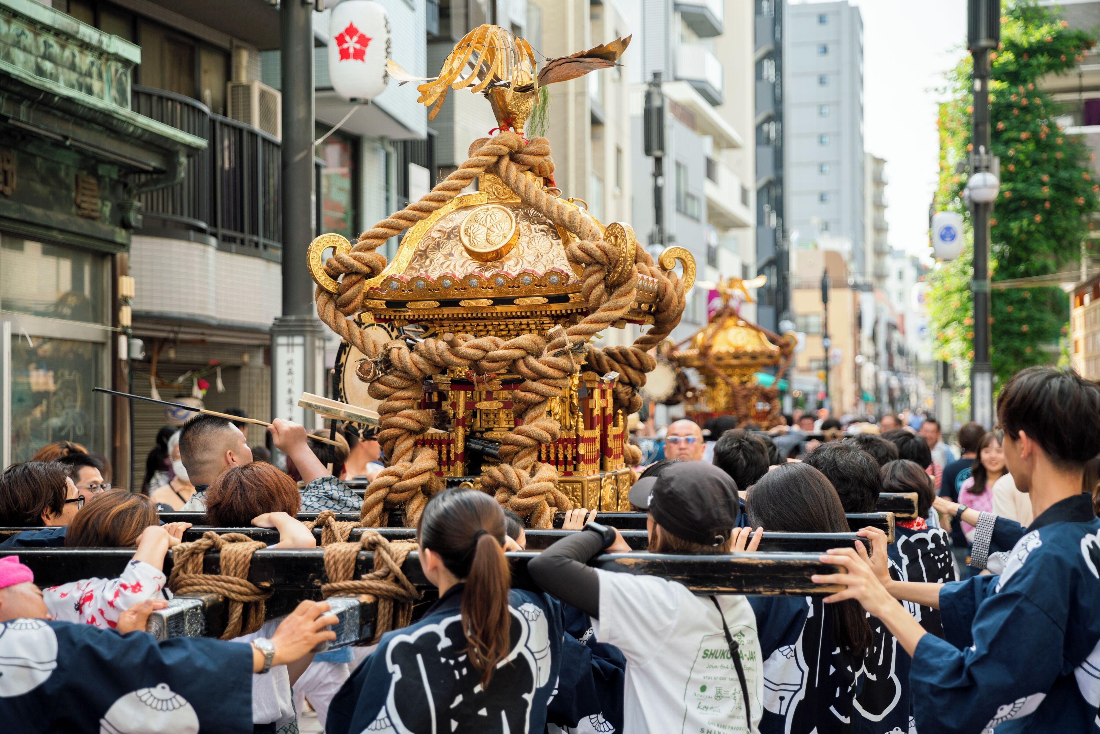 Una procesión tradicional con elaboradas estructuras doradas portadas por participantes.
