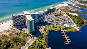 An aerial view of a coastal hotel with multiple buildings, a parking lot, and a marina. - Pinnacle Port A533 (Panama City Beach)
