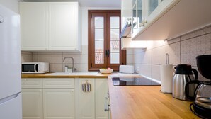 A compact kitchen with white cabinets, a microwave, a toaster, and a coffee maker.