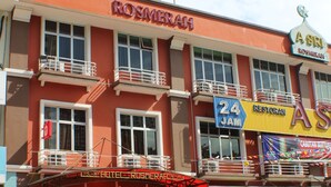 A hotel with a prominent 'HOTEL' sign, a '24 JAM RESTORAN' sign, and a 'ROSMERAI' sign. - Hotel Rosmerah (Malacca City)