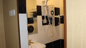 A bathroom with a sink, a mirror, and a shower unit. - Hotel Rosmerah (Malacca City)