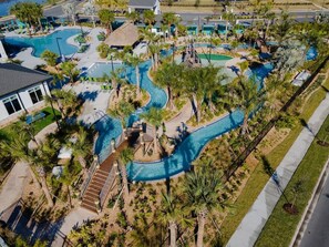 Oversigtsbillede af et resort med flere swimmingpools, palmer og en snoet vandrutsjebane.