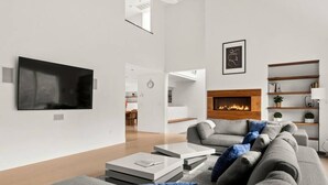 A modern living room with a fireplace, a television, and a sofa.