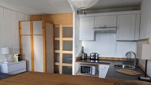 A compact kitchen with white cabinets, a microwave, a toaster, and a sink. - LES Glaciers Studio 25m2 (Les Belleville)