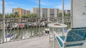 A balcony with a view of a marina and buildings. - 4541 Bay Beach Ln #345 (Fort Myers Beach)