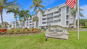 A sign for Royal Pelican Private Condominium with a clear view of the building's exterior, including balconies and a well-maintained lawn. - 4541 Bay Beach Ln #345 (Fort Myers Beach)