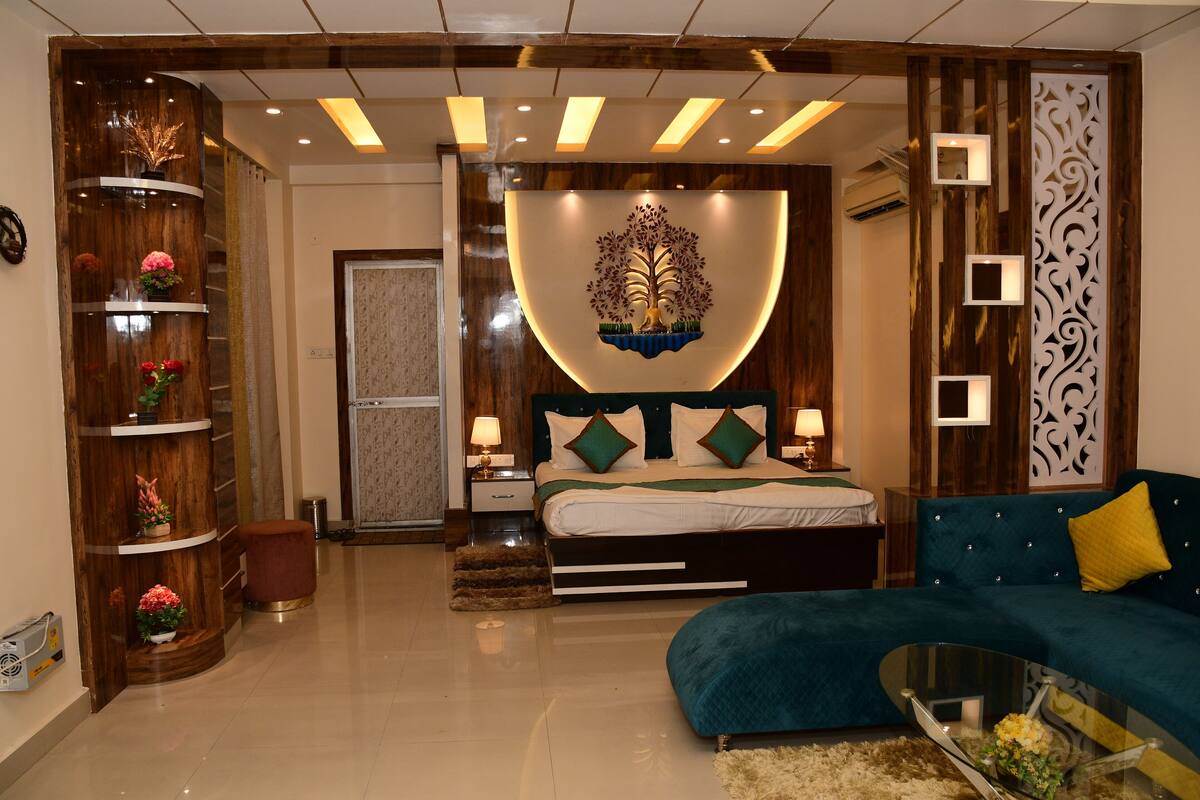 A modern bedroom with a bed, a sofa, a decorative wall, and a wooden cabinet.