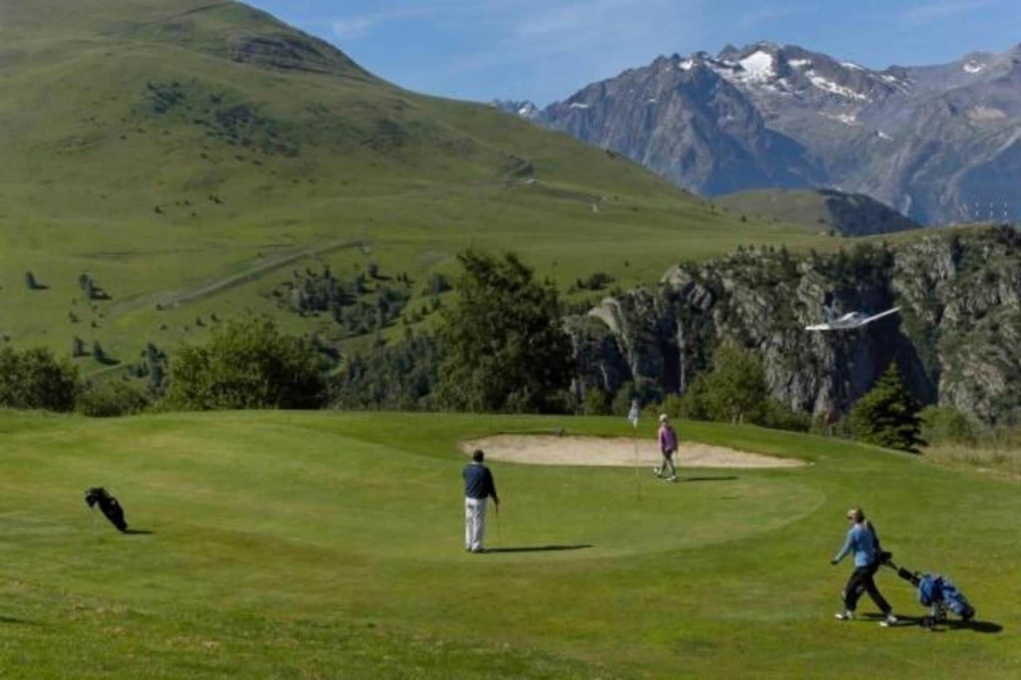 Un parcours de golf avec une chaîne de montagnes en arrière-plan.