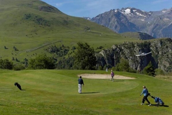 A golf course with a mountainous backdrop.