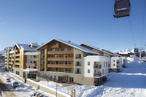 A multi-story hotel with a ski lift in the background.