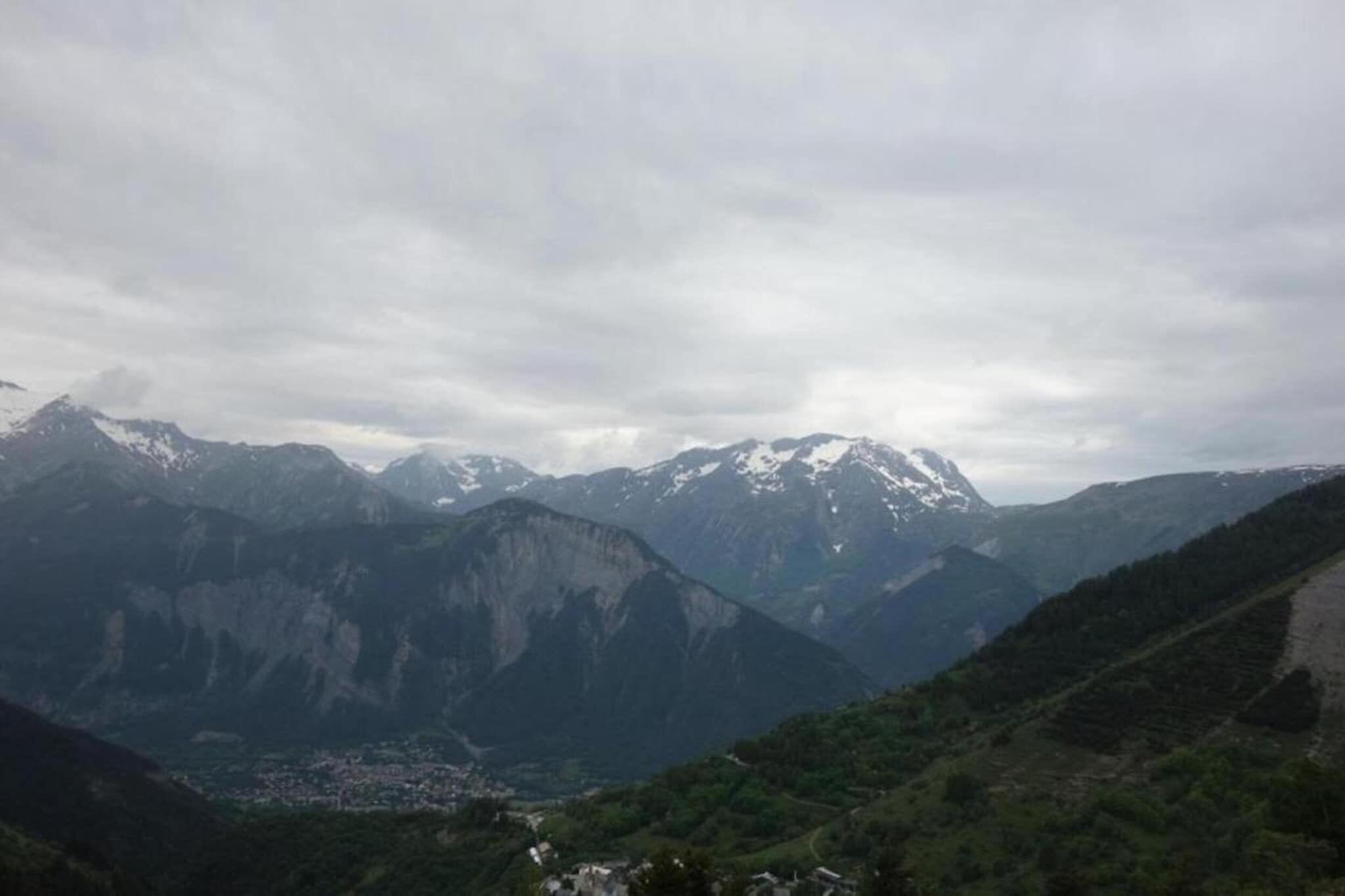 Un paisaje montañoso con un valle y una ciudad abajo.