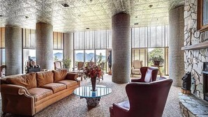 A spacious lobby with a leather sofa, a round glass coffee table, and a red armchair. - 2-bedroom condo near Sugar Mountain Resort (Sugar Mountain)