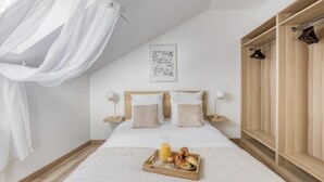 A bedroom with a bed, bedside tables, a wooden wardrobe, a hanging light, and a framed picture on the wall. - Cosy Home Chic Milly la Forêt/ Fontainebleau (Milly-la-Forêt)