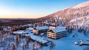 A snow-covered lodge with multiple buildings, surrounded by a forested mountain area. - Ski-Inn Kultakero (Pyhätunturi)