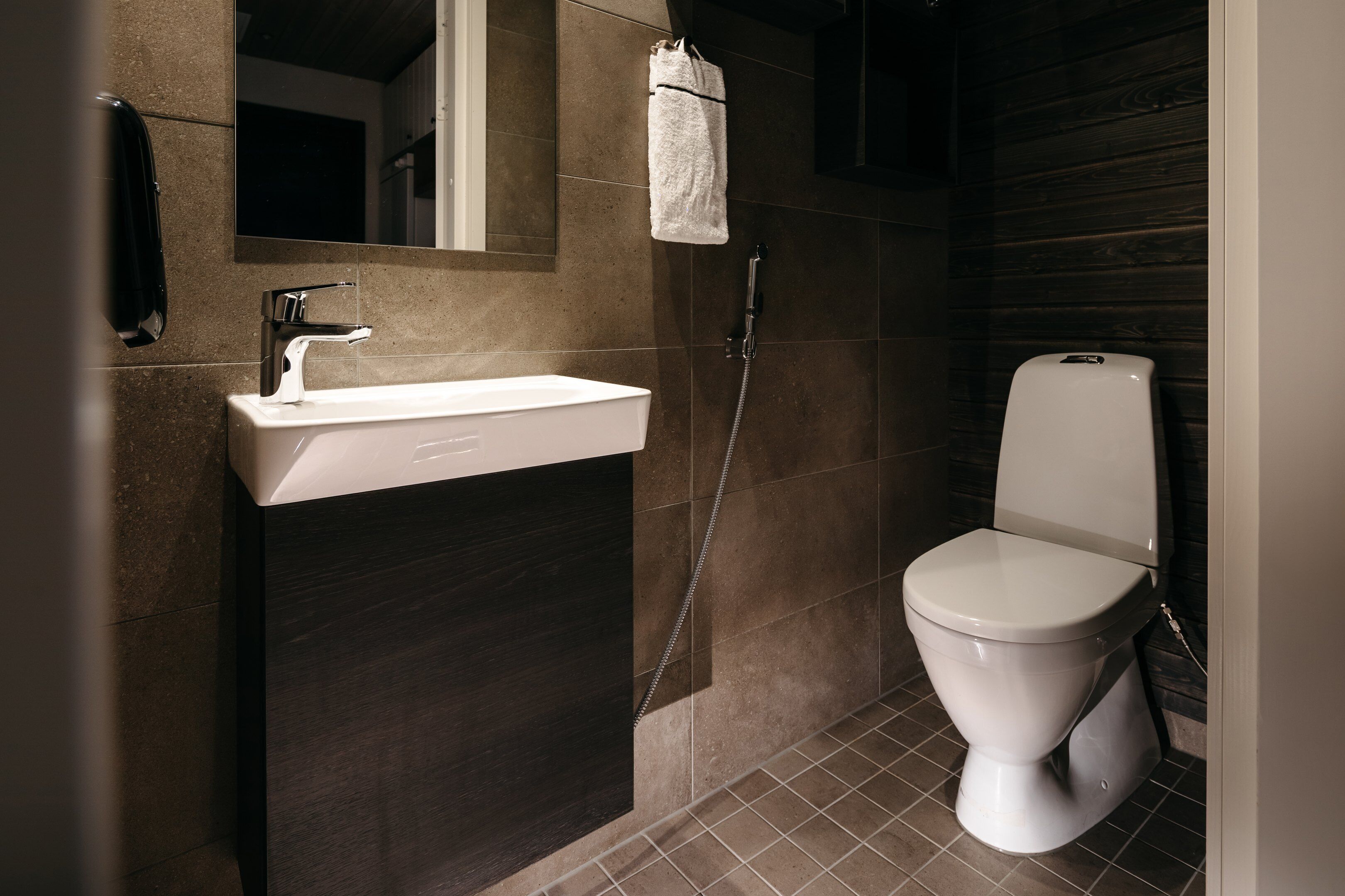 A modern bathroom with a white sink, a toilet, and a shower.